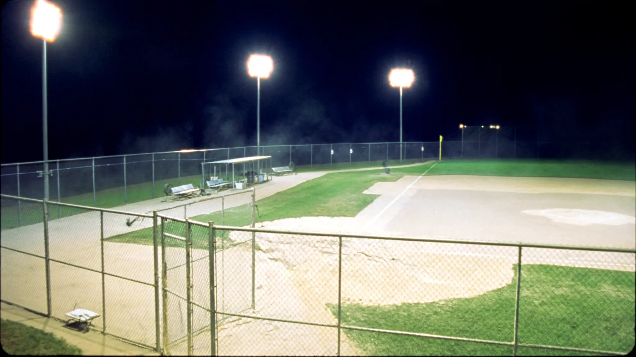 An empty ballfield at night with every floodlight on
